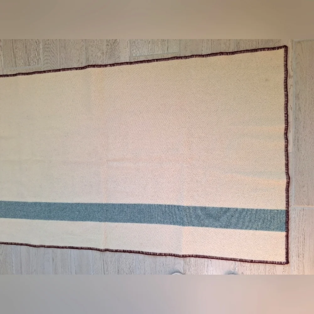 The Woolrich Woman cream, brown and blue Woolrich sheep logo heavy wool blanket